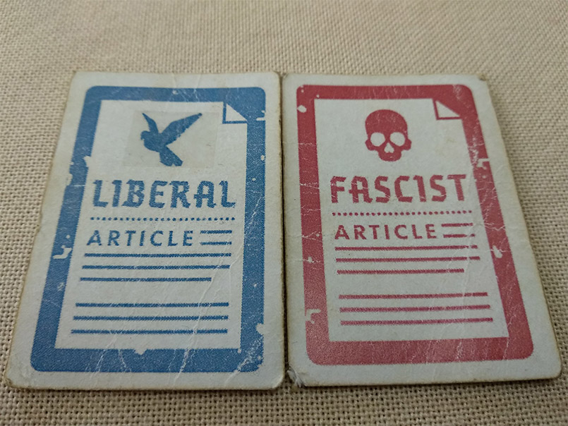 Image shows a liberal policy marked with a piece of tape and an unmarked fascist policy card